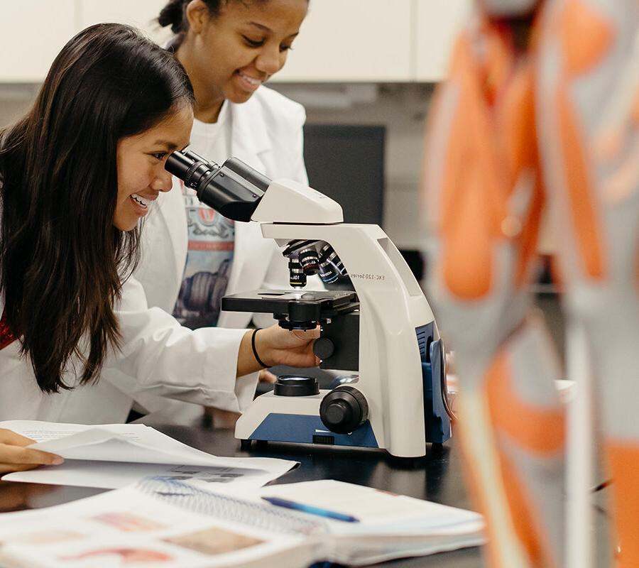 Student looks into a microscope in a laboratory session.